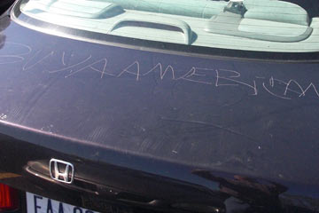 Car with "Buy American" scratched on trunk