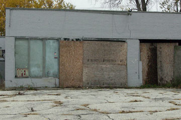 Boarded up storefronts with Open sign