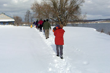 A group of people walking single file in snow