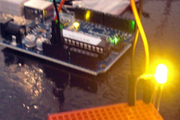 LED glowing yellow, Arduino board in background