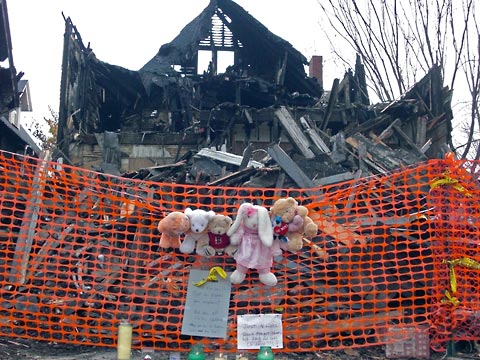 View of burned out house from sidewalk