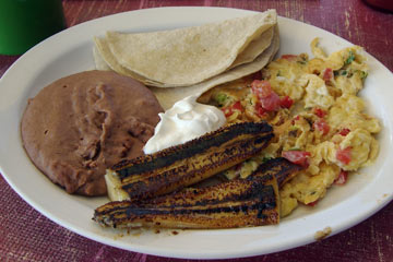 Plate of eggs, beans, tortillas and fried bananas
