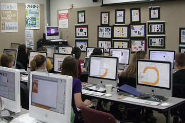 Students in computer lab with students, artwork on walls