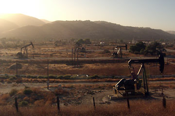 Oil wells with mountains in the background