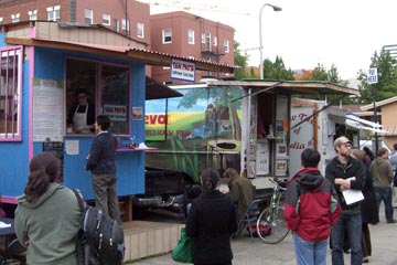 Colorful food vendors operating out of trailers parked streetside