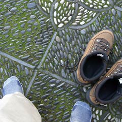 Boots and stocking feet on pebbled walkway