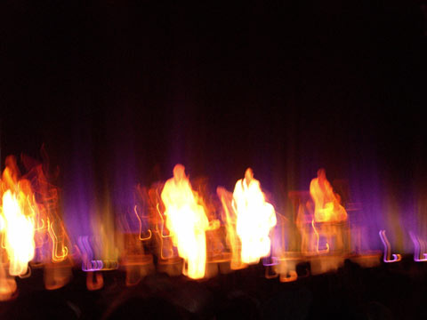 Blurred image of David Byrne and band performing