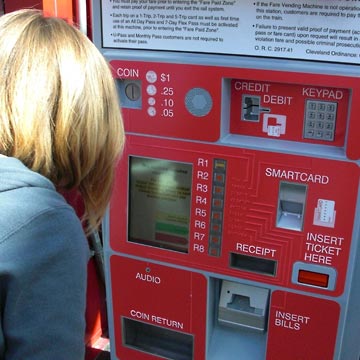 Young woman looking at fare machine