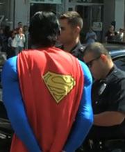 Man in Superman costumer, two cops