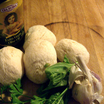 Olive oil, mushrooms, garlic on cutting board