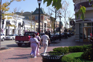 People walking down tree-lined sheet in Legacy Village