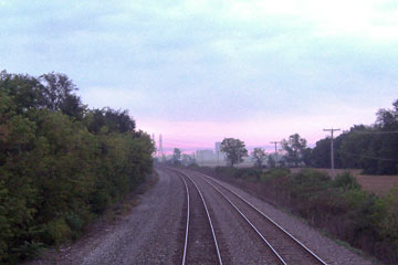 Rosy sunrise on the horizon, tracks in foreground