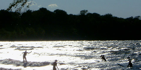 Surfers in Lake Erie near sunset